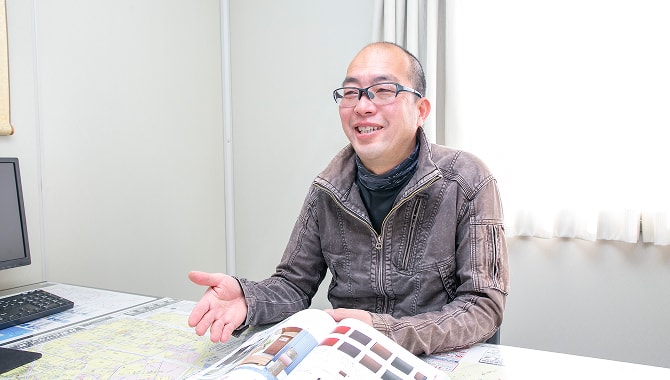 机に資料を広げて打ち合わせする様子